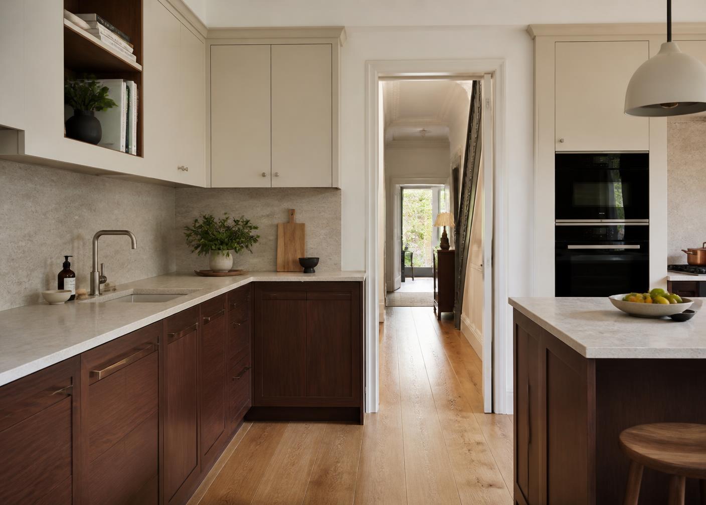 Completed kitchen fitting in Ealing with walnut cabinetry, stone worktop and pocket door